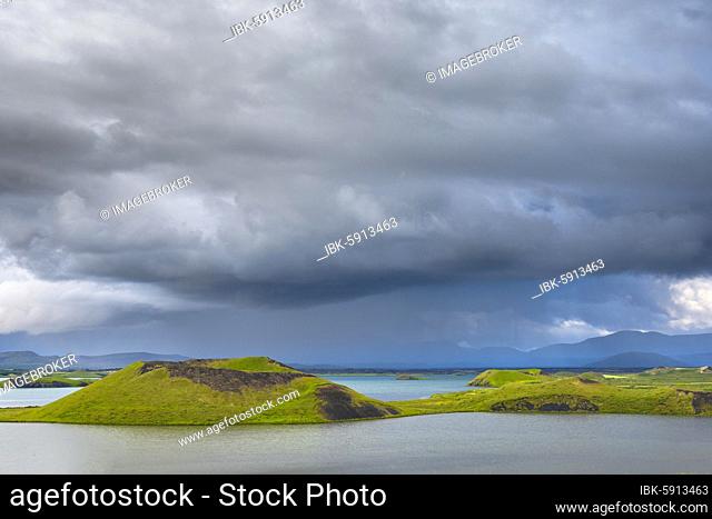 Green pseudo-crater, volcanic crater, with dramatic clouds at Lake Mývatn, Skútustaðir, Norðurland eystra, Iceland, Europe