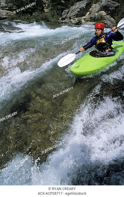 A kayaker negotiating the Elbow River in Bragg Creek, Alberta, Canada