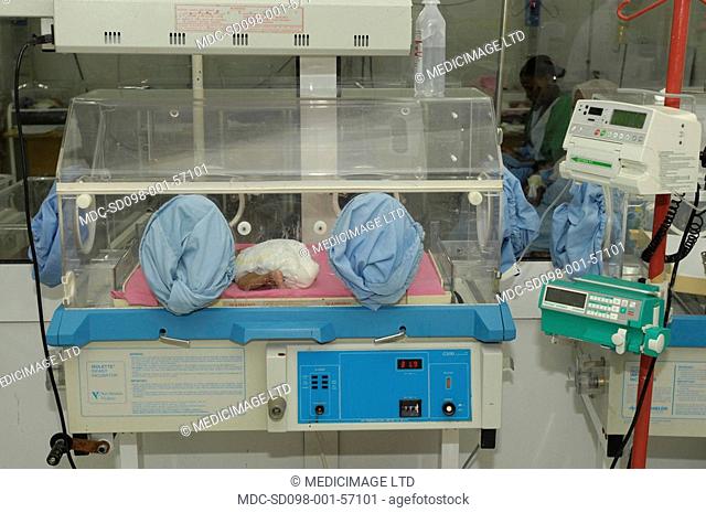 A premature baby in an incubator in the neonatal unit of a hospital. Premature babies are placed in incubator as they have not fully developed the mechanisms...