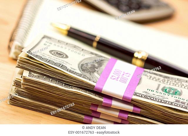 Stack of Money, Calculator, Paper and Pen