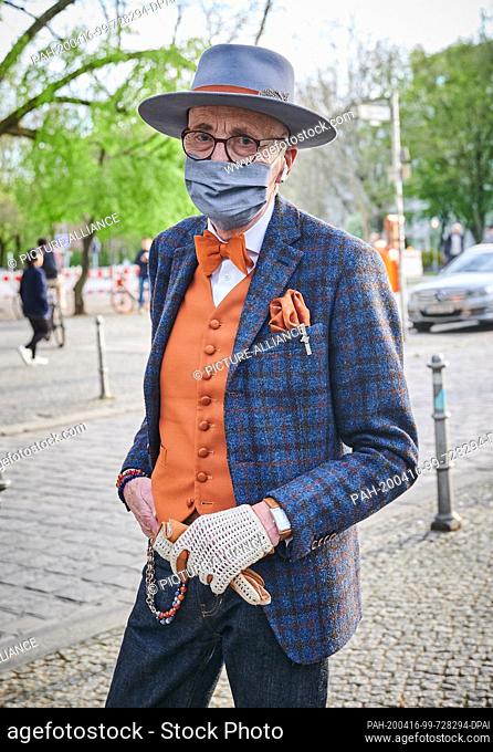 16 April 2020, Berlin: Male model and hipster grandfather Günther Anton Krabbenhöft stands at the Admiralbrücke in Kreuzberg with a mouth guard