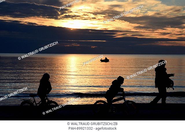 Cyclists at sunset on Sunday evening at the Baltic Sea near the town of Vitte, on the island of Hiddensee in Germany, 16 April 2017