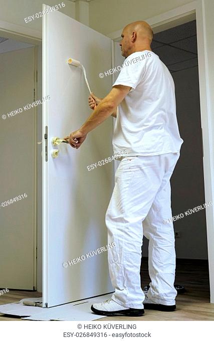 craftsmen in the paint a door in an office building