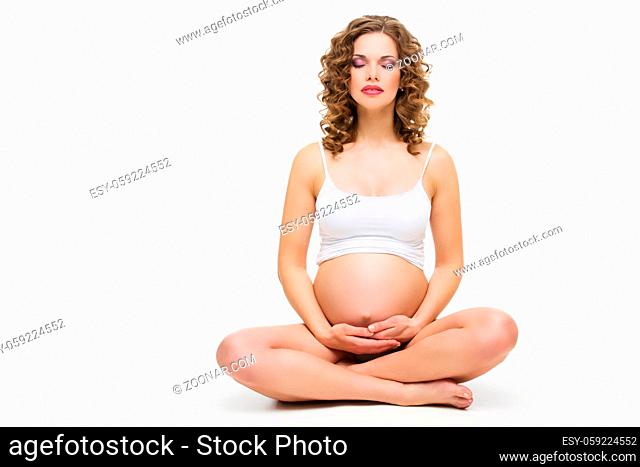 Pregnant woman practicing yoga, sitting isolated on white