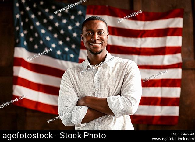 A Smart African-American Man, Young Successful Entrepreneur Crossed His Arms Smiling Amid America's National Flag, Patriotism Concept