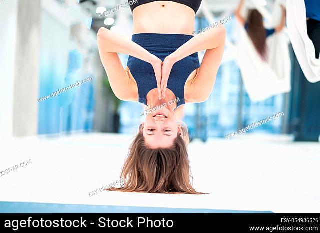 Woman hanging upside down in a hammock. Fly yoga class. Healthy lifestyle, healthy hobby