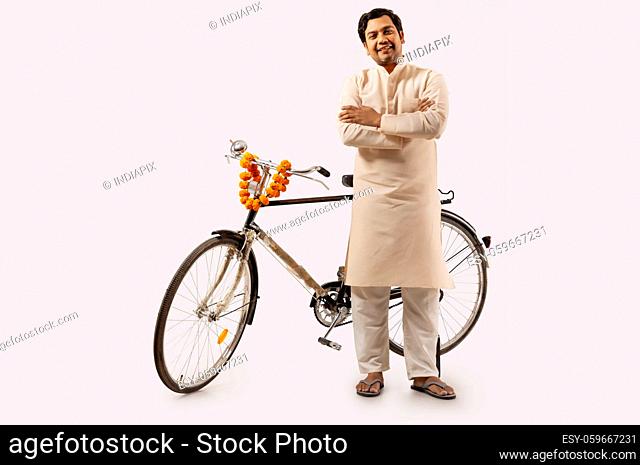 A RURAL MAN CONFIDENTLY POSING WHILE STANDING WITH NEW BICYCLE