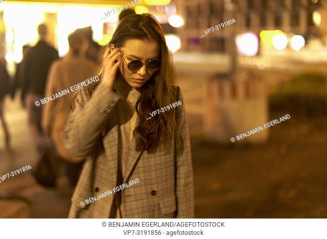 Fashionable woman on the street by night. Munich, Bavaria, Germany