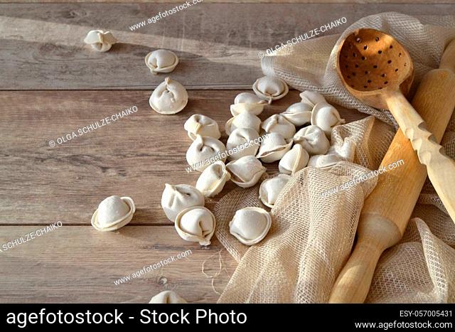 Raw russian pelmeni. Wooden shabby table in rustic style