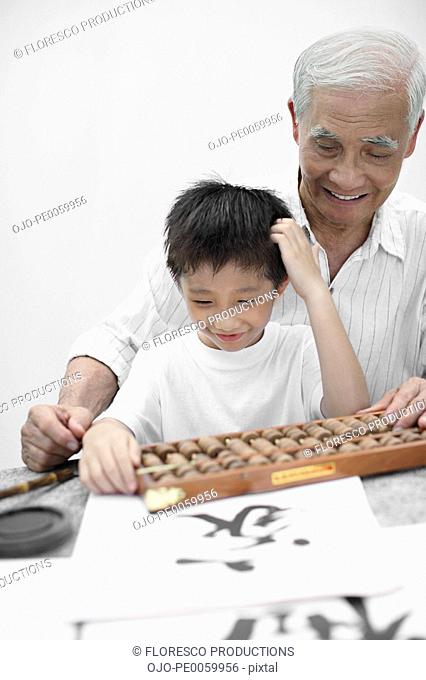 Man and young boy indoors at table with abacus