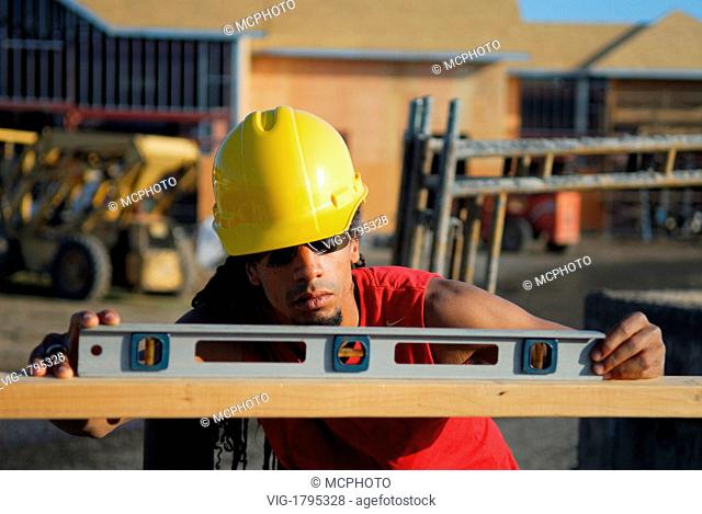 Construction worker checking the level of a plank of wood - 21/06/2007