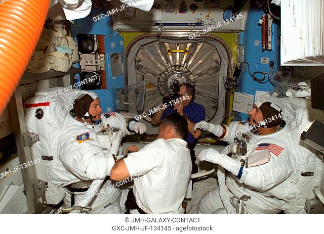 Astronaut Paul S. Lockhart, STS-113 pilot, assists astronauts Michael E. Lopez-Alegria (left) and John B. Herrington, STS-113 mission specialists