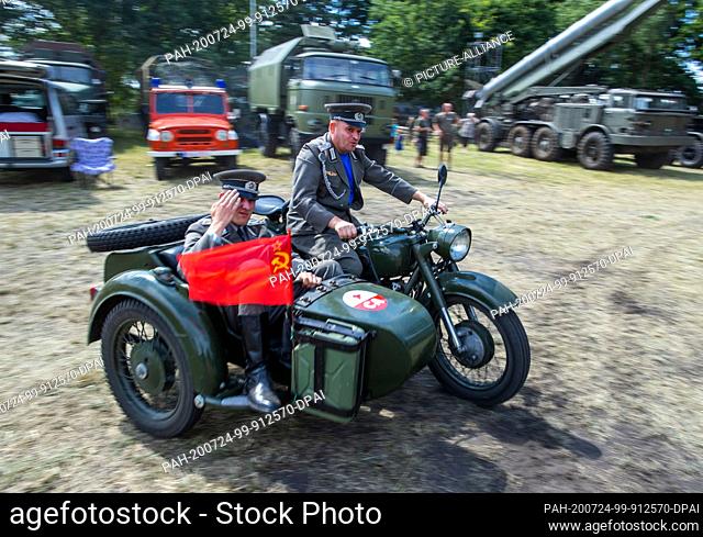 24 July 2020, Saxony-Anhalt, Beuster: Collectors ride a motorcycle team of the Soviet Red Army across the exhibition grounds during the Blue Light Days in the...