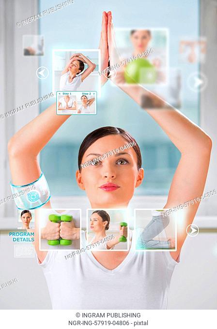 Woman doing yoga exercise wearing smart wearable device with futuristic interface