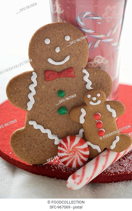 Gingerbread men and sweets in front of festive glass