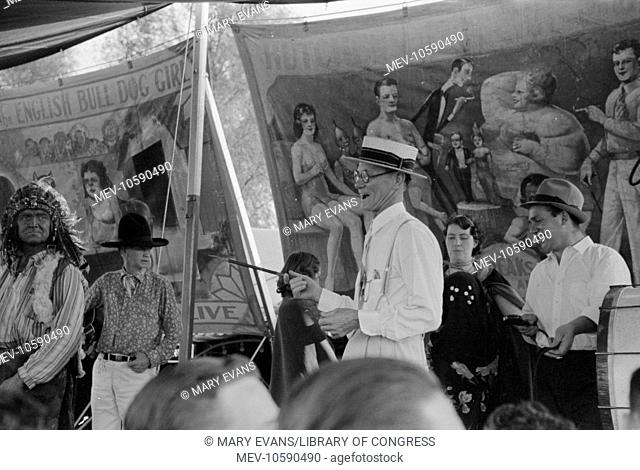 Barker at sideshow with performers, state fair, Donaldsonville, Louisiana. Date 1938 Nov