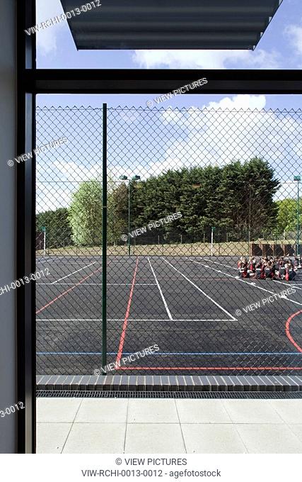 Trinity School Sports Hall, Newbury, United Kingdom. Architect ADP Architects Ltd, 2012. View of all weather sports pitch from viewing window in main sports...