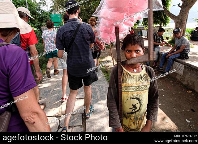 A boy selling cotton candy in the street. Pokhara (Nepal), August 20th 2019