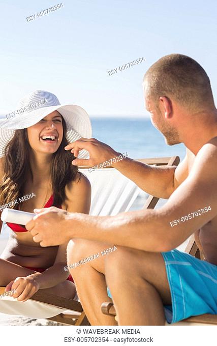 Attractive man applying sun cream on his girlfriends nose