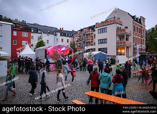 01 September 2023, Saxony, Aue-Bad Schlema: Numerous visitors brave the rain at the performance of the band Sedony with ex-Puhdy Peter Meyer at the ""Day of...
