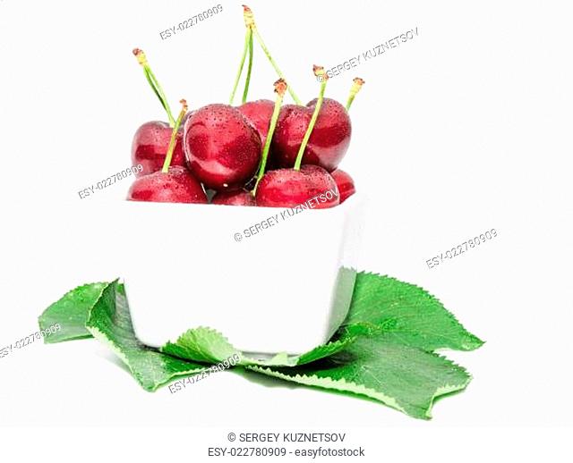 Small square bowl filled with juicy sweet cherry