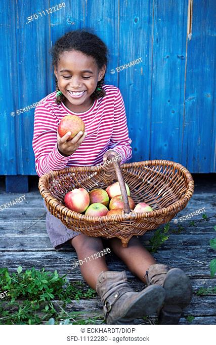 A laughing girl looking at an apple