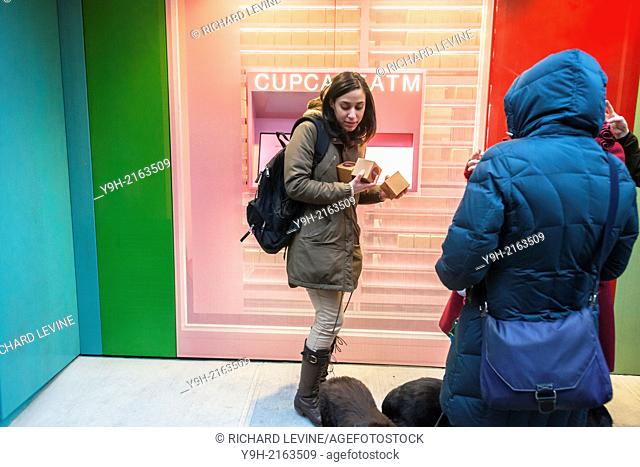 Cupcake lovers flock to the Sprinkles Cupcakes bakery's 24-hour cupcake ATM in New York on its grand opening day. The automated dispenser is located next to the...