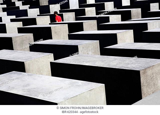 Lone person among concrete slabs at the Holocaust Memorial (Memorial to the Murdered Jews of Europe), Berlin, Germany
