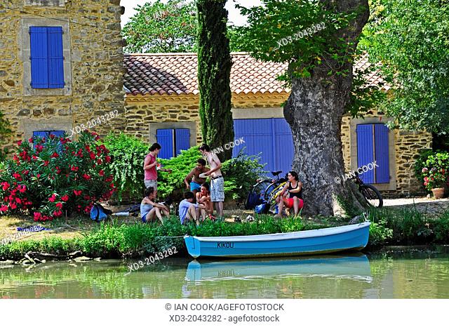 cyclists resting beside the Canal du Midi at Le Somail, Aude Department, France