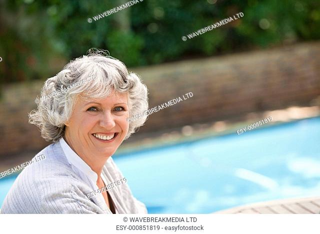 Smiling woman beside the swimming pool