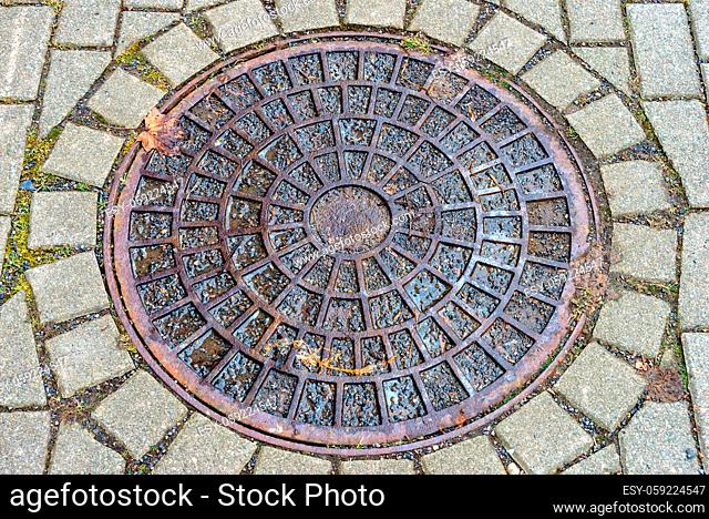 A big Round manhole cover on the footpath
