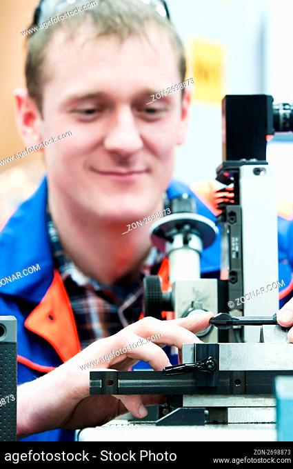worker in uniform checking quality of countersink reamer sharpening using precise optical device
