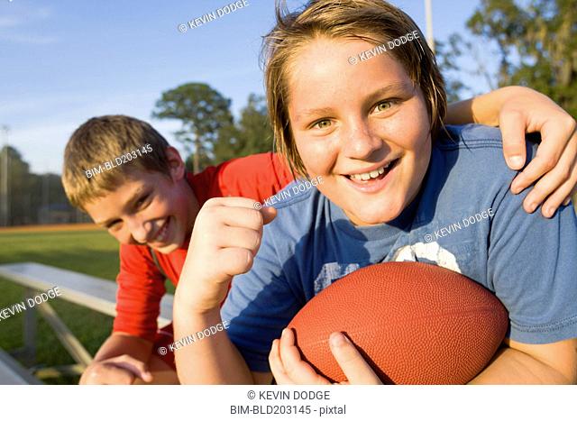 Caucasian boys holding football