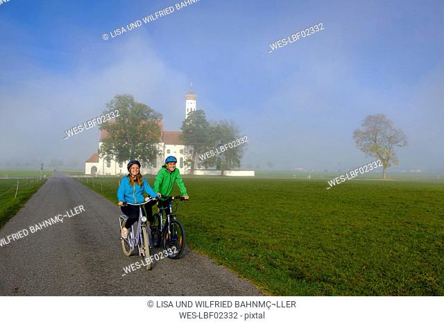 Germany, Pilgrimage Church St. Coloman and couple of cyclists on tour