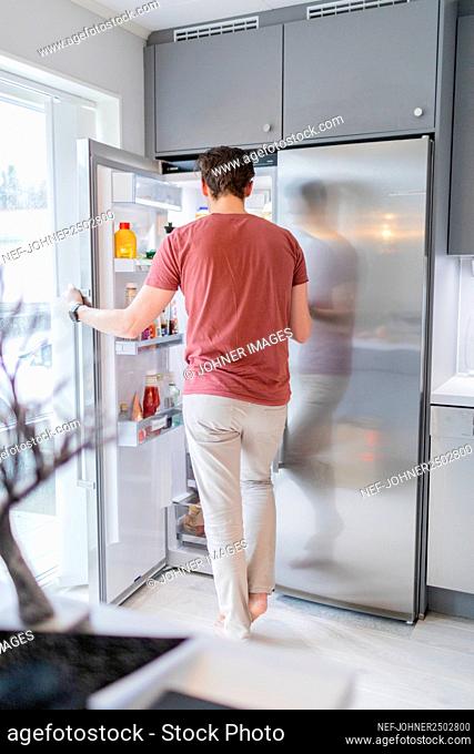 Man standing in front of open fridge