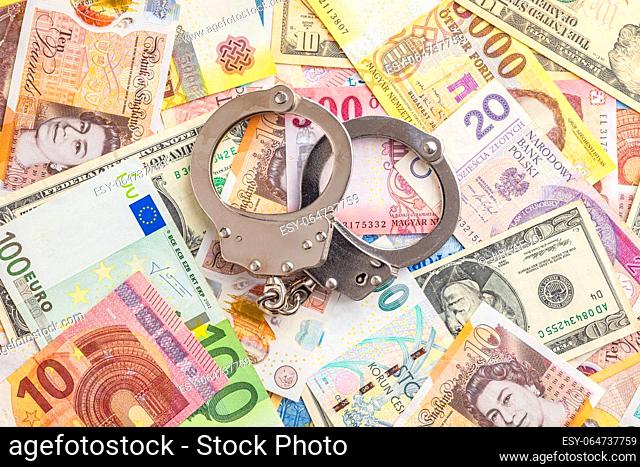 Handcuffs on the various banknotes background. Top view