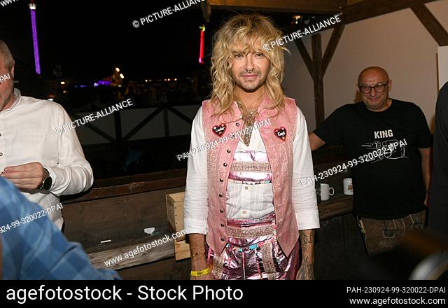 24 September 2023, Bavaria, Munich: The musician Bill Kaulitz stands with a pink leather pants in the beetle tent. The 188th Wiesn takes place this year from 16