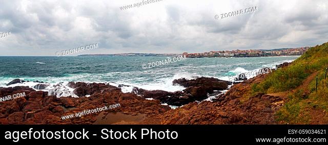 Waves crashing on rough shores. Sea waves crash and splash on rocks. Panoramic shot