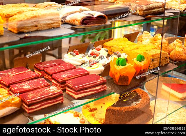 Different types of cakes pieces in pastry shop. Cake shop with sweets and desserts