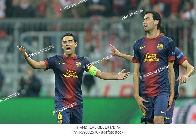 Barcelona's Xavi (L) and Busquets talk to the referee during the UEFA Champions League semi final first leg soccer match between FC Bayern Munich and FC...