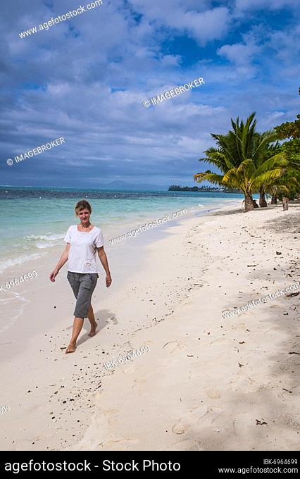 Woman walking along Lano beach in Savai'i, Samoa, South Pacific, Oceania