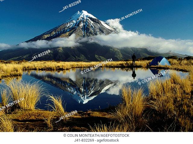 Camping beside tarn reflecting Mt Egmont / Taranaki on the Pouakai Range Egmont National Park New Zealand
