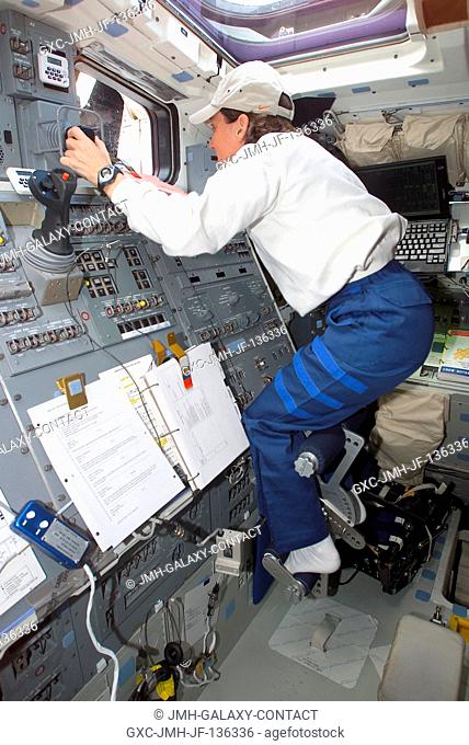 Astronaut Nancy J. Currie, mission specialist, works the controls for Columbia's Remote Manipulator System (RMS) on the crew cabin's aft flight deck