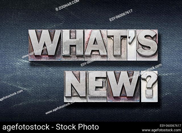 whats new question made from metallic letterpress on dark jeans background