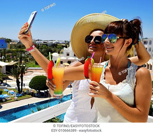Two young women taking picture of themselves on vacation. Selfie