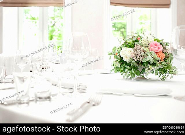 table setting, festive round tables ready for guests. Beautifully organized event. floral arrangement in the center. fresh flowers cut-off