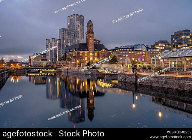 Sweden, Skane County, Malmo, City canal at dusk with World Maritime University and hotels in background