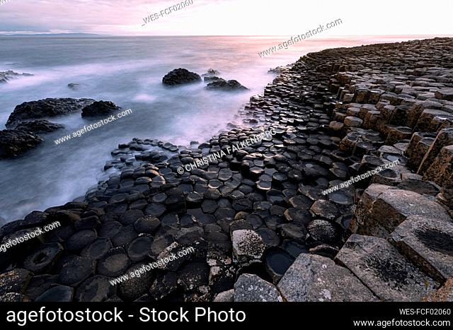 Waves rushing towards basalt stones at Giant's Causeway, Northern Ireland