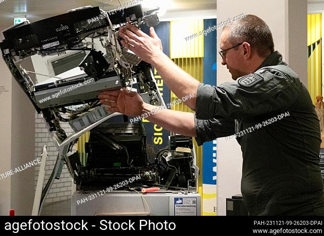 21 November 2023, Baden-Württemberg, Stuttgart: Police officer Stefan Knapp shows an ATM blown up by the police for experimental purposes at a press event at...