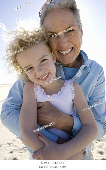 Grandmother and granddaughter posing on beach
